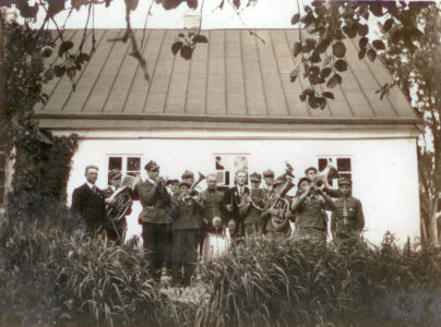 A church orchestra in front of the presbytery building in Raczki. The orchestra consists of residents of Małe Raczki. 1930s. Orkiestra kościelna przed budynkiem plebanii w Raczkach. W składzie orkiestry mieszkańcy Małych Raczek. Lata 30. XX wieku.