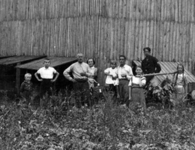 Aleksander z żoną, dziećmi i pracownikami na tle suszarni. Aleksander z żoną, dziećmi i pracownikami na tle suszarni.
